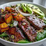 Butternut squash steak bowls with smoky seared steak, vibrant greens, and creamy avocado drizzled with zesty lime-cilantro dressing.