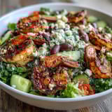 Colorful Greek Shrimp Bowl served over mixed greens with briny olives and crumbled feta.