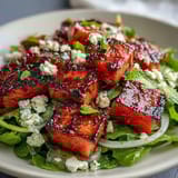 Sweet and smoky grilled watermelon salad with crumbled feta, fresh mint, and balsamic drizzle.