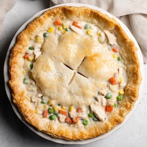 Freshly baked Chicken Pot Pie with a crisp, egg-brushed crust served beside a simple green salad.