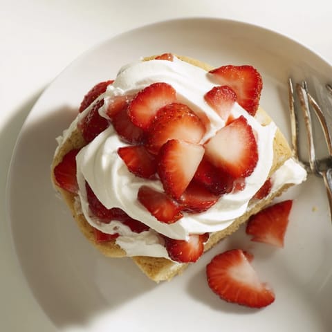 Sliced ripe strawberries glisten with sugar and lemon juice for the Strawberry Shortcake.