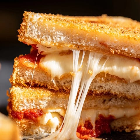 Freshly grilled Mozzarella Stick Grilled Cheese served with a small bowl of warm marinara.