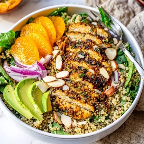 Citrus Herb Chicken Salad Bowl with juicy orange segments, creamy avocado, and herb-grilled chicken on fresh greens and quinoa.