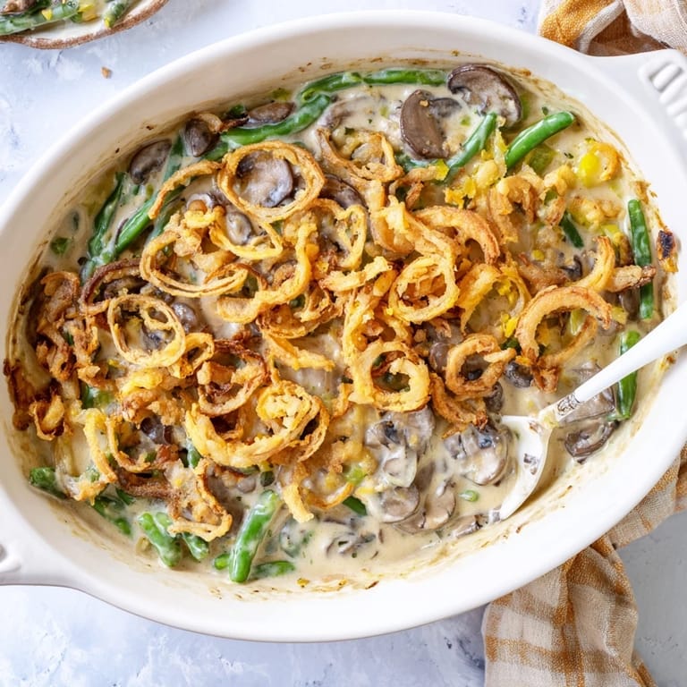 Close-up of creamy Green Bean Casserole featuring tender green beans and sautéed mushrooms in rich sauce.