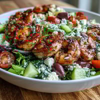 Freshly grilled Greek Shrimp Bowl with feta, cucumbers, tomatoes, and zesty lemon dressing.
